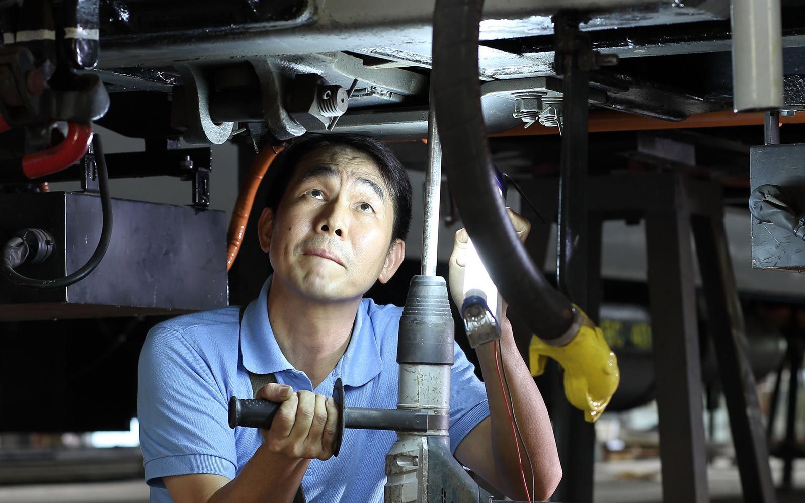 Technician working under a coach